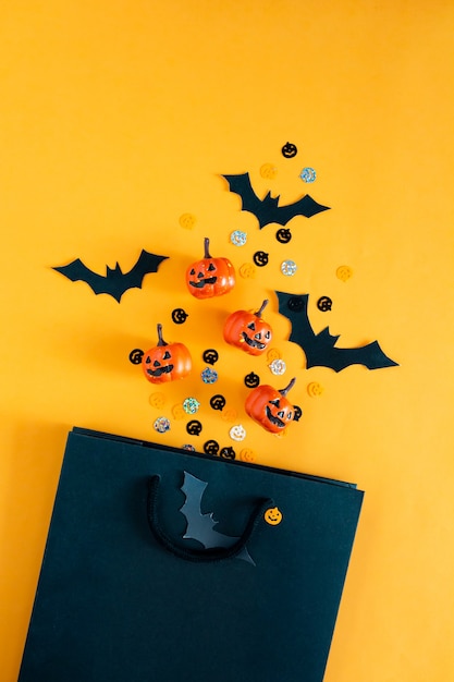 Calabazas de Halloween murciélagos objetos de fiesta y bolsa de compras plana vista superior copia espacio