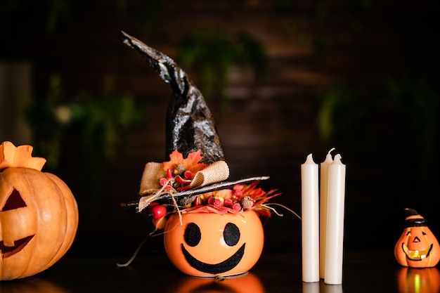 Calabazas de Halloween con sombrero de bruja negro sobre su fondo de madera. Jack-o-lantern en la celebración de Halloween