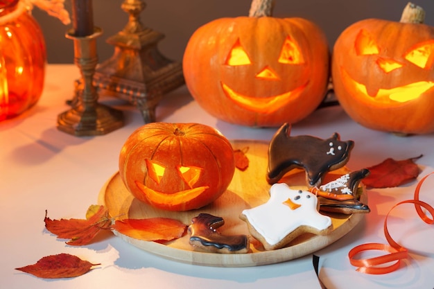 Calabazas de Halloween con velas encendidas en la mesa blanca