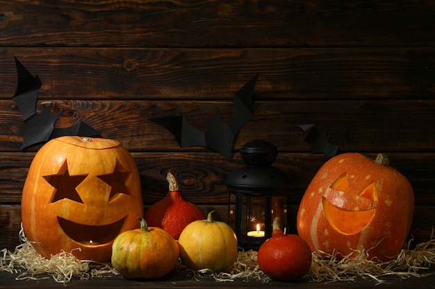 Calabazas de Halloween y velas en la mesa de madera oscura, espacio de copia