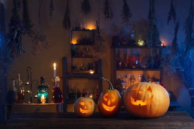 Calabazas de Halloween con velas y pociones mágicas en la noche interior