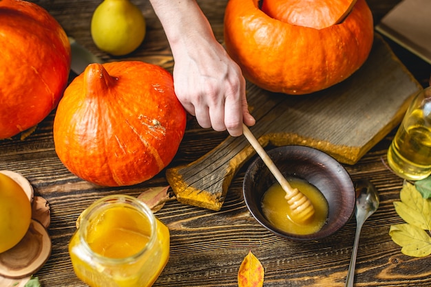 Foto calabazas naranjas para hornear con miel y canela sobre fondo de mesa de madera