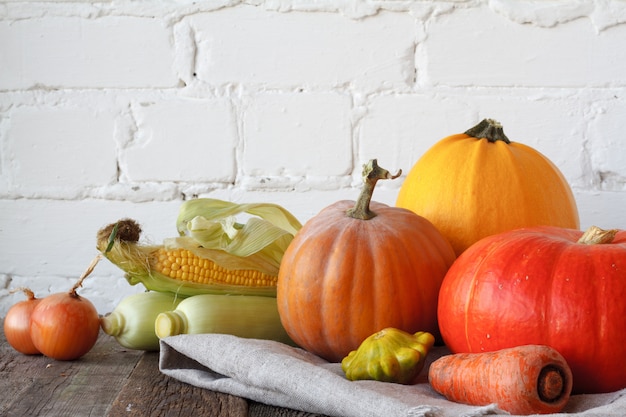 Calabazas de otoño y otras verduras en una mesa de madera de acción de gracias