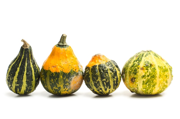 Calabazas pequeñas naturales sobre un fondo blanco.