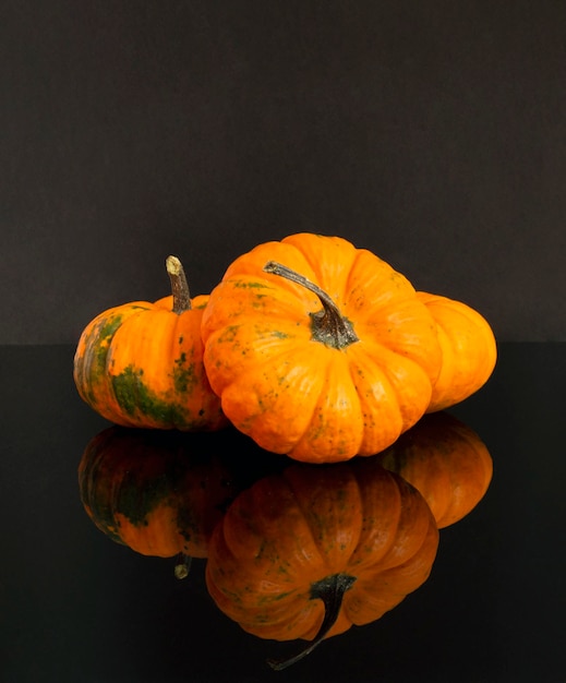 Calabazas sobre un fondo negro con reflejo