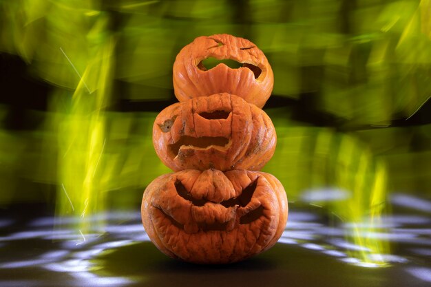 Foto calabazas talladas para halloween con fondo negro y luces de colores