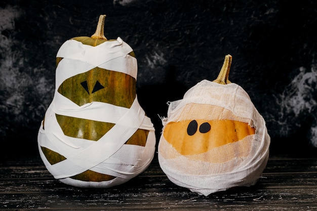 Calabazas zombies en vendas sobre un fondo oscuro El concepto de Halloween