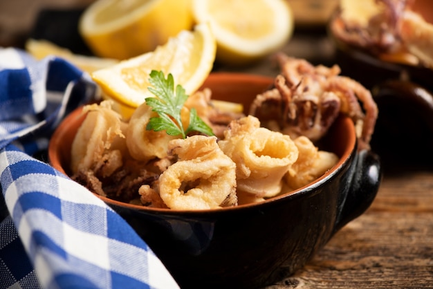 Calamares fritos italianos tradicionales y una rodaja de limón de cerca