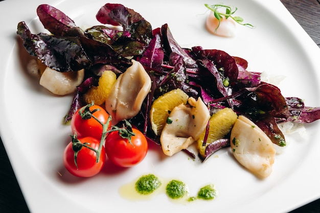 Calamares con tomate naranja y ensalada