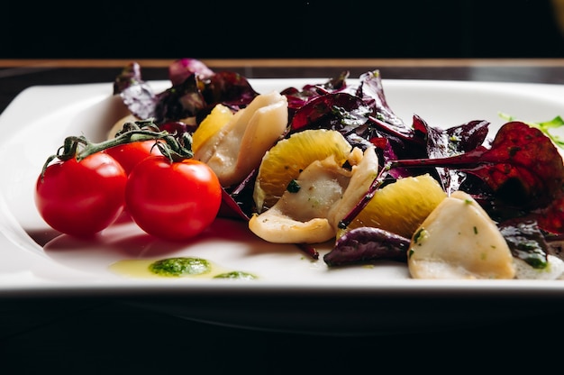 Calamares con tomate naranja y ensalada