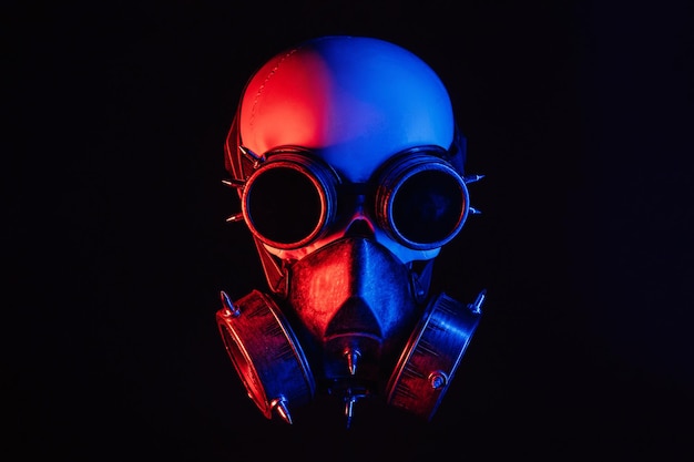 Calavera humana con gafas steampunk y máscara de gas con luz de neón roja y azul