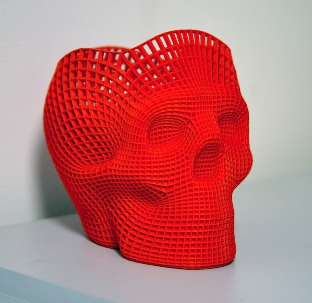 Calavera impresa con plástico de color rojo en impresora 3d.