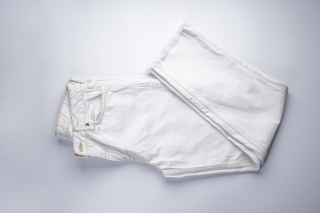 Calça jeans branca empilhada, vista superior.