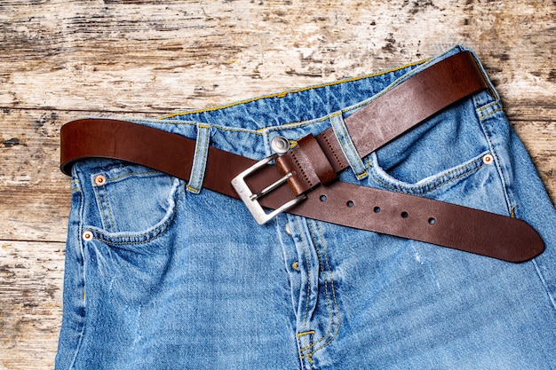 Calça jeans com cinto na textura de madeira velha.