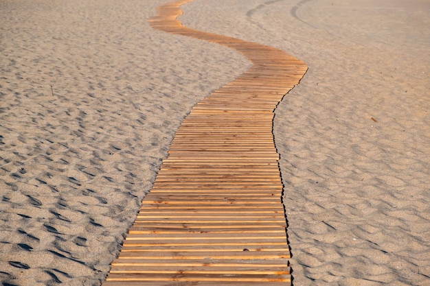 Calçadão de praia Pranchas de madeira enrolando passagem vazia na praia arenosa Elafonissos ilha Grécia