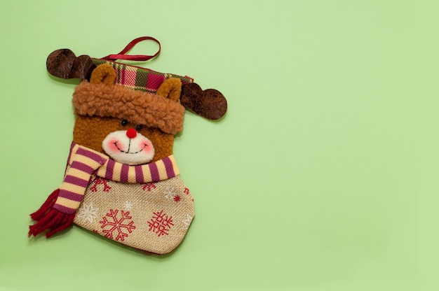 Calcetín de Navidad para regalos en forma de oso sobre un fondo verde