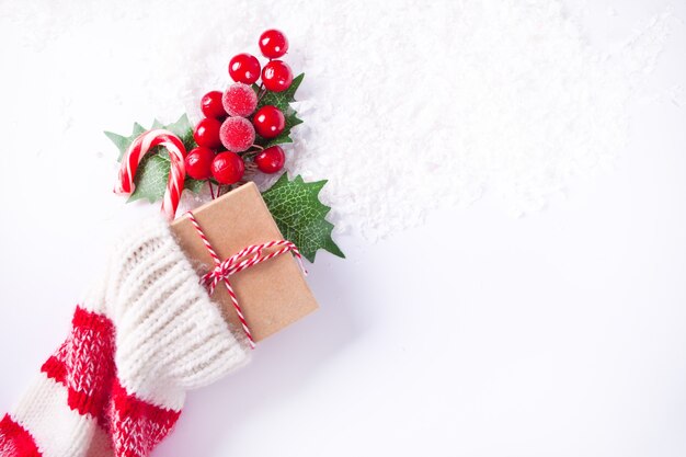 Calcetín de punto de decoración navideña con bastón de caramelo, caja regalo y baya. Vista superior. Copie el espacio.