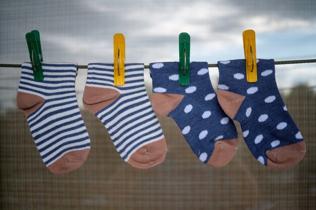 Calcetines de bebé después de lavarlos en una cuerda con pinzas para la ropa de colores