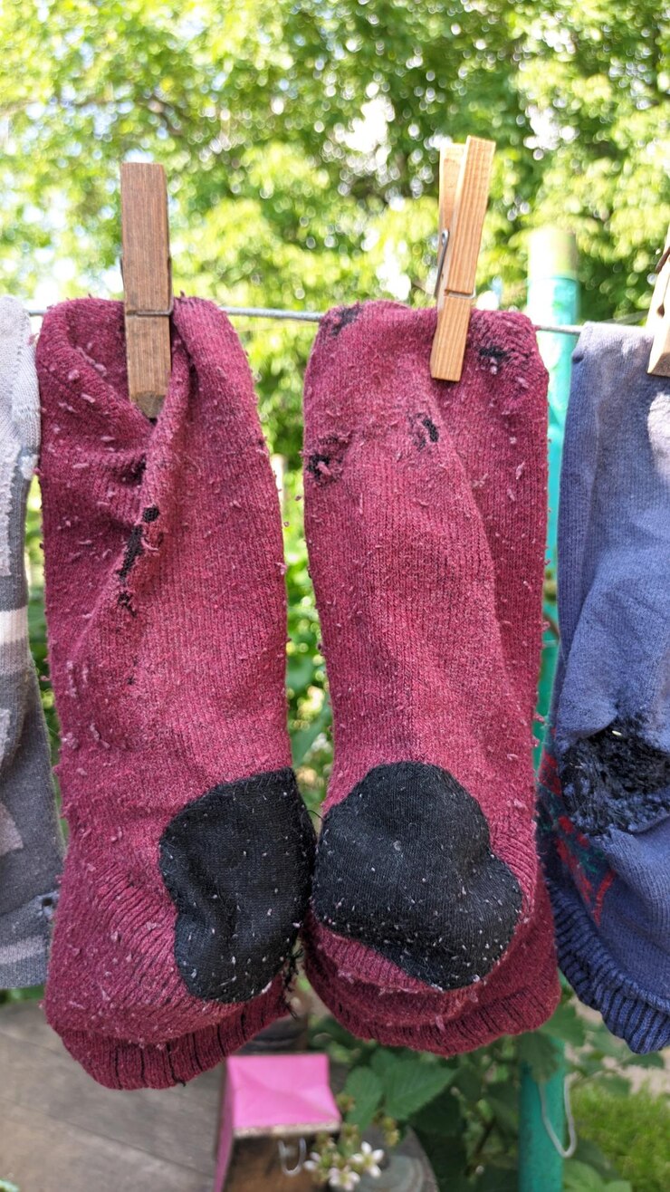 Foto calcetines viejos y cosidos limpios colgando de alambre en el verano al aire libre