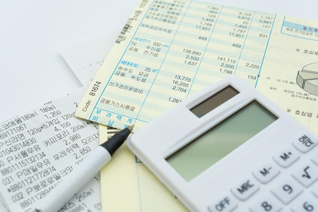 Una calculadora y un bolígrafo están encima de una pila de papeles.