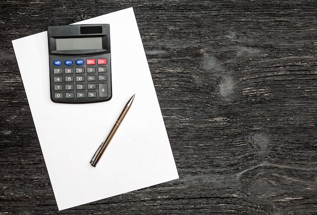 Calculadora con un bolígrafo en una hoja de papel en blanco