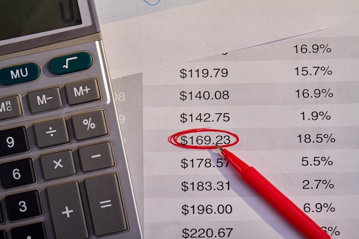 Foto calculadora con bolígrafo rojo y facturas con el número indicado. concepto de beneficios contables.