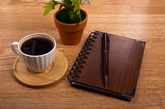 Calculadora de café y cuaderno sobre fondo de madera