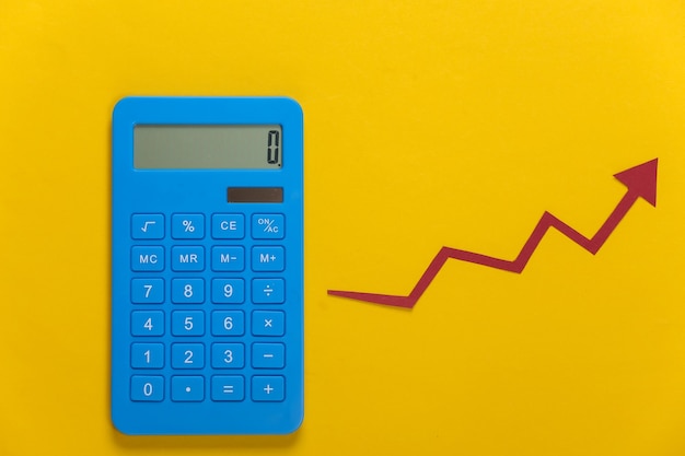 Calculadora com seta de crescimento vermelha em amarelo. Gráfico de setas subindo. O crescimento econômico