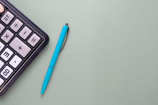 Calculadora com uma caneta esferográfica em um fundo de textura de couro