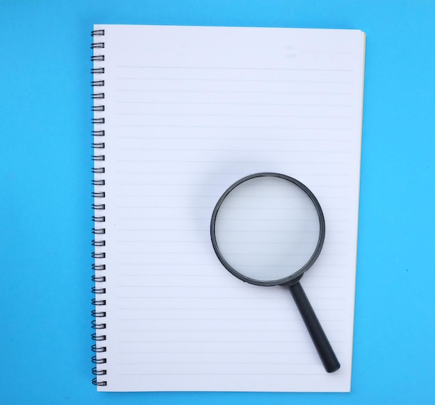 Una calculadora y un cuaderno en el escritorio azul de la oficina