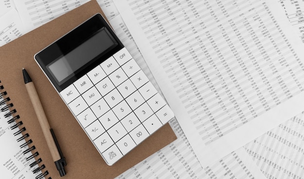 Calculadora con cuaderno sobre documentos financieros Concepto financiero