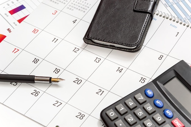 Calculadora de caneta e smartphone no calendário