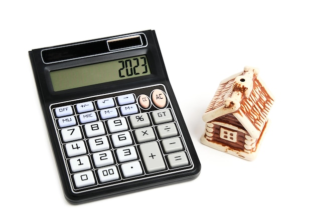 Calculadora e casa em uma hipoteca de conceito de fundo branco comprando e vendendo habitação