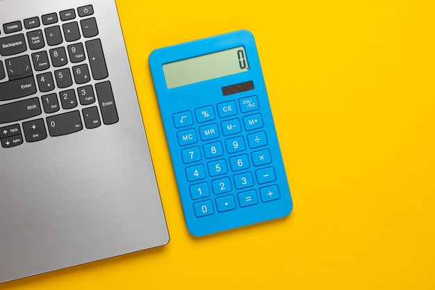 Calculadora e laptop em um amarelo