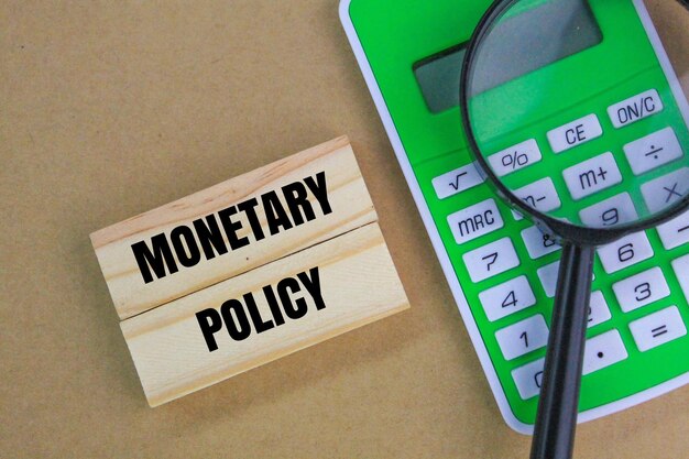 calculadora e lupa com a palavra política monetária