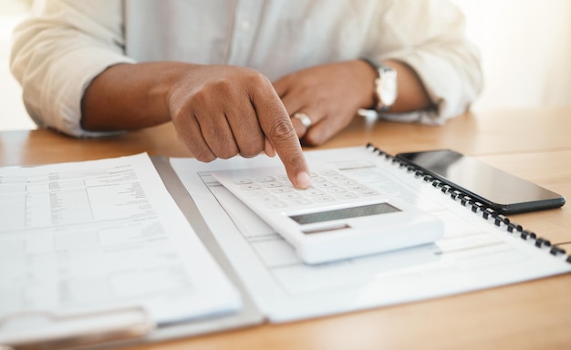 Calculadora finança e planejamento com mãos de mulher negra para pagamento de orçamento e cálculo de economia Auditoria fiscal e documentos com senhora em casa para contas de despesas bancárias e papelada de fatura