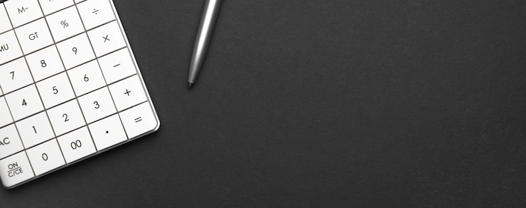 Calculadora y lápiz sobre fondo negro