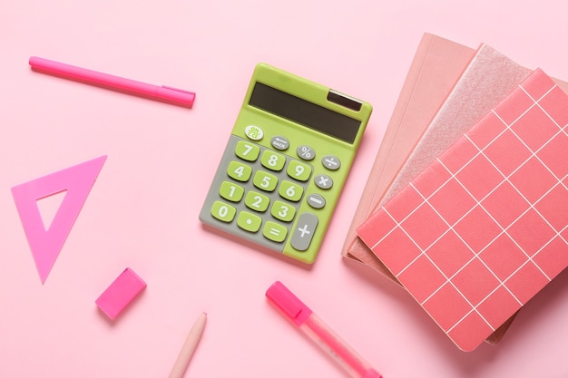 Calculadora moderna e papelaria na superfície colorida