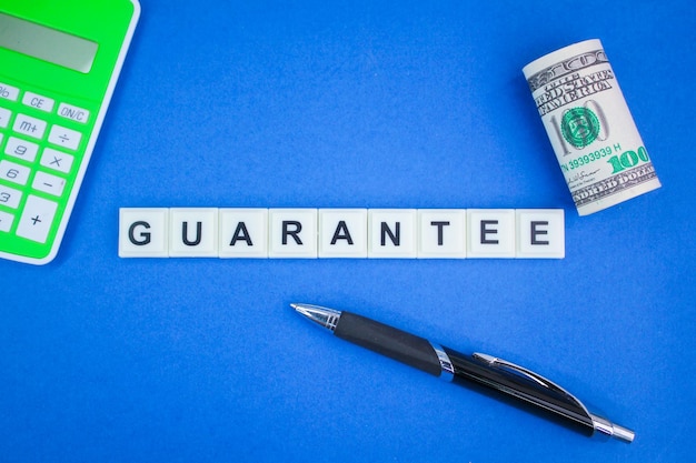 calculadora, papel moneda y bolígrafo con la palabra garantía. el concepto de garantía y garantía