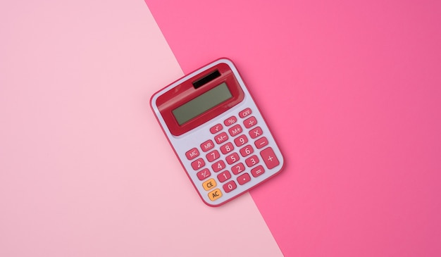 Calculadora de plástico rosa sobre superficie rosa, vista superior