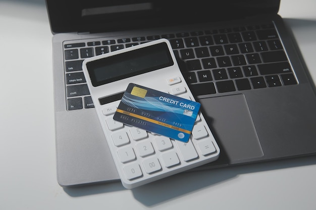Calculadora sobre un fondo oscuro tarjetas y billetes de plástico