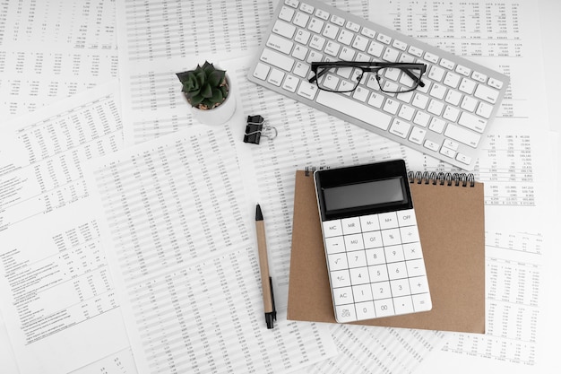 Calculadora teclado lupa caneta óculos deitado em documentos financeiros Conceito financeiro e de negócios Vista superior