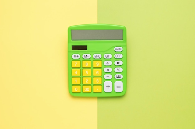 Calculadora verde-amarelo em um fundo verde-amarelo O conceito de negócios e educação