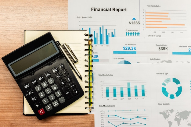 Calculadora de vista superior y papeleo en la mesa en la sala de reuniones