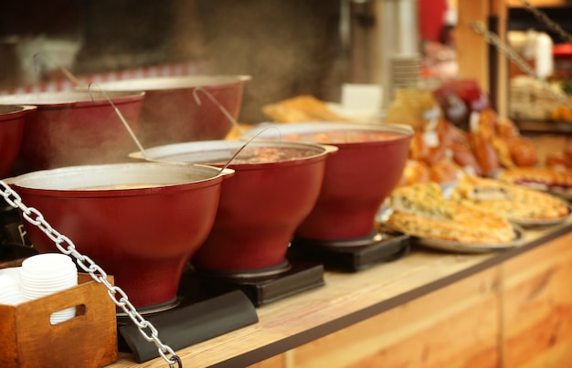 Caldeirões com vinho quente no balcão do quiosque da feira de natal