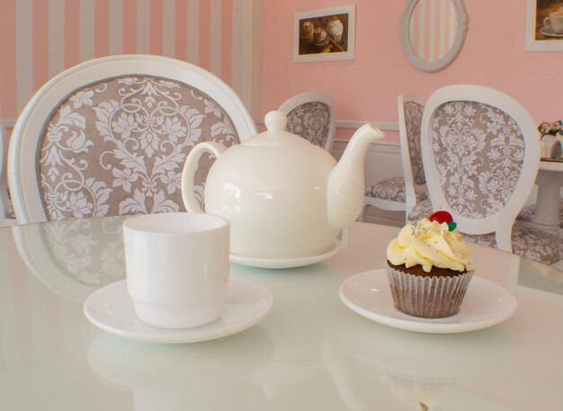 Foto caldera kaffeetasse und cupcake in einem pinkfarbenen café-ambiente
