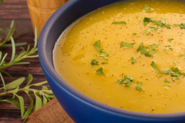 Caldo de crema de mandioca caliente en un tazón blanco sobre una mesa de madera