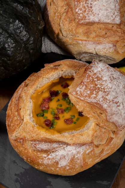 Caldo de abóbora com bacon em cima de pão italiano.