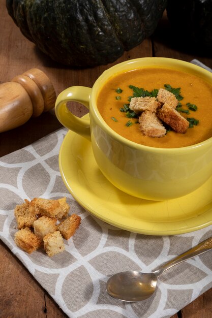 Caldo de abóbora com fundo de madeira.