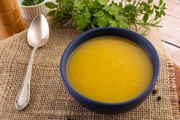 Caldo de creme de mandioca quente em uma tigela branca sobre uma mesa de madeira